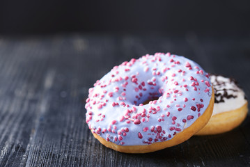 Donuts with blue and vanilla icing on a dark background