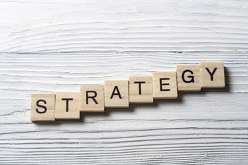 Fototapeta premium Strategy word on wooden cubes, success in business concept.