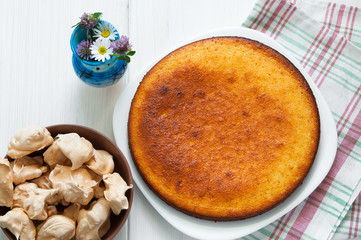 Top view: brown meringues and manna semolina pie on white wooden table