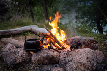 Campfire and the old kettle in twilight