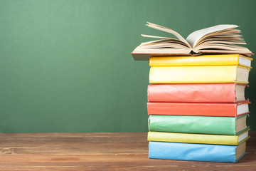Open book, hardback books on wooden table. Education background. Back to school. Copy space for text.