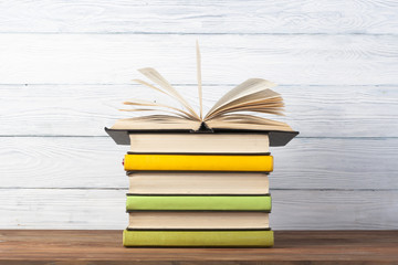 Open book, hardback books on wooden table. Education background. Back to school. Copy space for text.