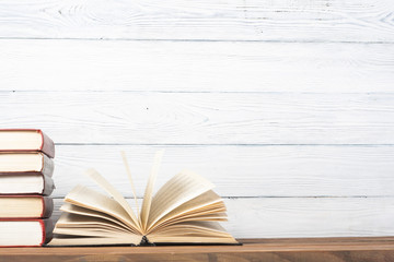 Open book, hardback books on wooden table. Education background. Back to school. Copy space for text.