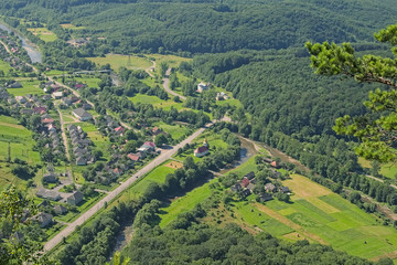 Fototapeta na wymiar Small village between the mountains. View from the Mountain Vusok Kamin (High Stone). Zhdenievo. Zakarpatska oblast, Ukraine.
