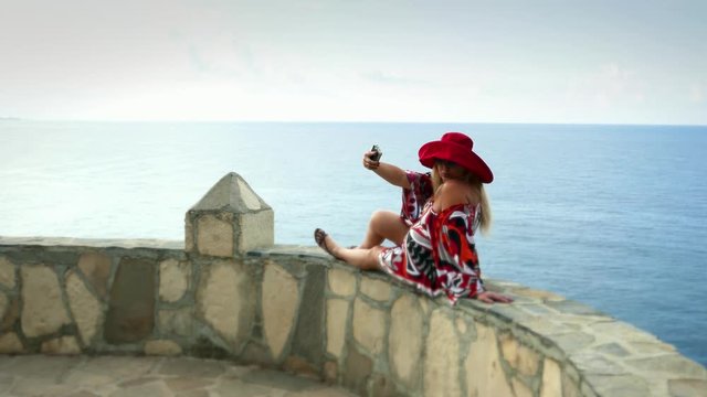 Cute glamorous caucasian woman european lady makes shooting selfie , romantic female tourist resting near sea