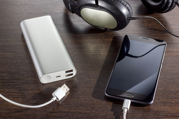 mobile phone and power bank battery on dark background