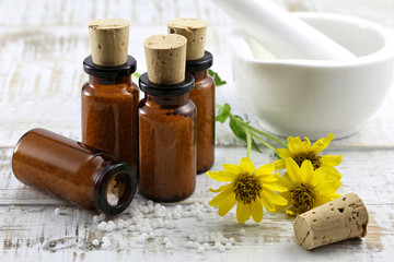 homeopathic arnica pills on wooden background - obrazy, fototapety, plakaty