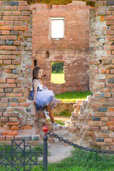 Obraz na płótnie Canvas fashion photo of a beautiful girl on a background of brick ruin