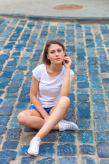 beautiful girl sitting on the pavement