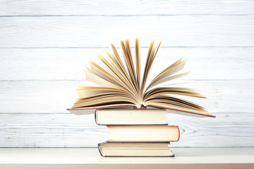 Fototapeta premium Open book, hardback books on wooden table. Education background. Back to school. Copy space for text.