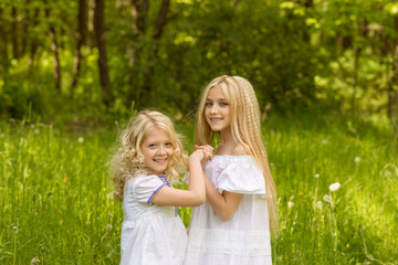 Two young girls relaxing on nature in summer