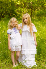 Two young girls relaxing on nature in summer