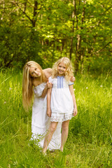 Two young girls relaxing on nature in summer