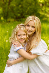 Two young girls relaxing on nature in summer