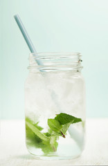 glass of cold water with fresh mint leaves and ice cubes