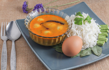 close up to Thai vermicelli eaten with curry, egg, vegetable and flower 