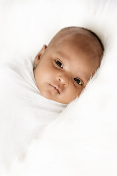 Three weeks old baby sleeping on white blanket cute infant newborn lying down close up shot eyes open