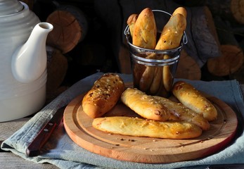 Homemade small baguettes in bucket and on the chopping boards