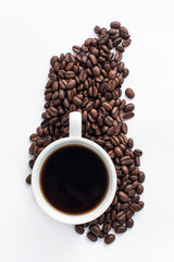 Cup of coffee arranged with fresh roasted coffee beans