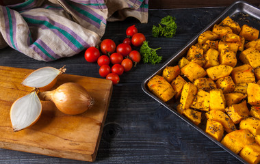 Selection of ingredients for cooking pumpkin soup: roasted pumpkin, tomato, onion. Rustic table