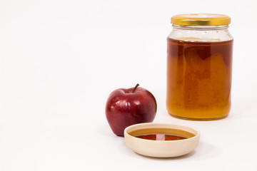 Red apple and jar of honey bowl of honey isolated on a white background