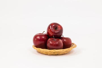 Ripe red apples in wicker basket isolated on white background