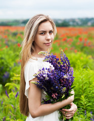 Naklejka na ściany i meble girl with bouquet of lupine flowers