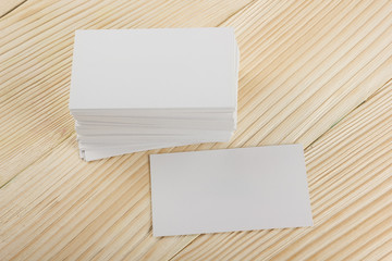 White blank business visit card, gift, ticket, pass, present close up on wooden background. Copy space corporate identity package Template for ID