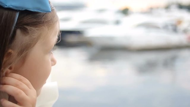 portrait of a little girl three years with the blue bow on her head, which is smiling