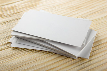 White blank business visit card, gift, ticket, pass, present close up on wooden background. Copy space corporate identity package Template for ID