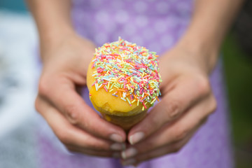 Ice cream with sprinkles held with two hands by lady
