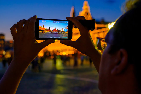 Male tourist taking picture of landmarks by smart phone at night