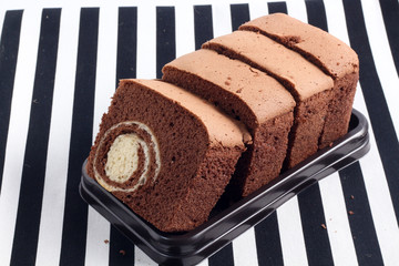 belgium chocolate cake loaf focus on slice on wood with sackclot