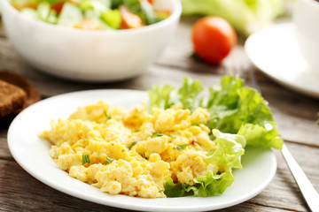 Scrambled eggs with vegetables on a grey wooden table