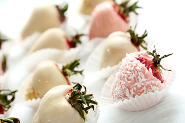 Strawberries covered in chocolate on a white wooden table