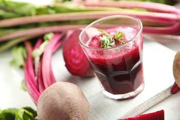 Fresh beets juice in glass on a white wooden table