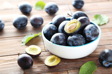 Tasty and ripe plums on brown wooden table
