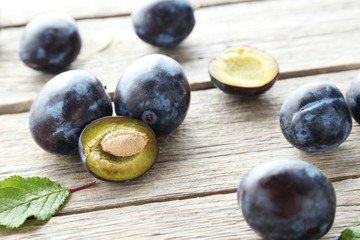 Tasty and ripe plums on grey wooden table