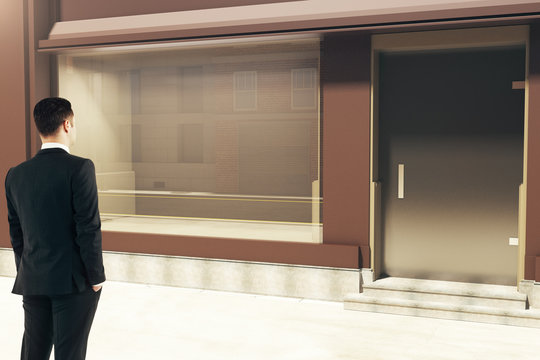 Confident businessman looking at storefront