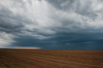 Dark stormy clouds over plow in late april.
