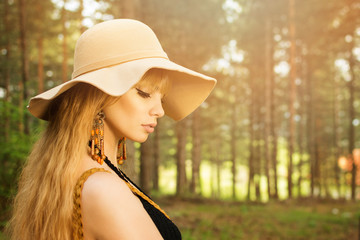 Gorgeous young boho blonde woman in floppy hat outdoors