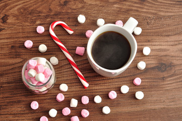 A mug filled with black coffee surrounded with small white and p