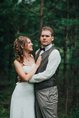 Fototapeta premium Bride and groom are embracing against the background forest