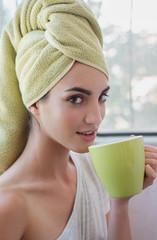 Beautiful young woman with morning cup of hot beverage.