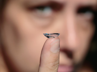 chica sosteniendo lente de contacto