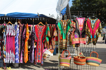 Brightly colored African fashions displayed at an outdoor flea market