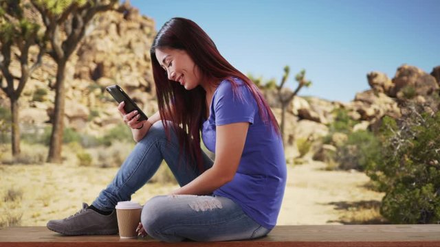 Asian woman resting on a nearby bench in the desrt