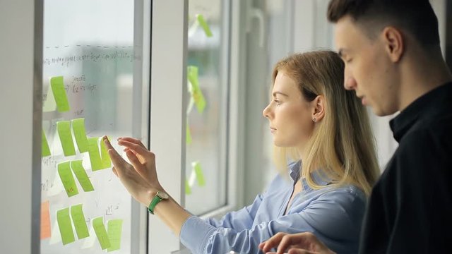 Woman and man are creating working process plan pointing