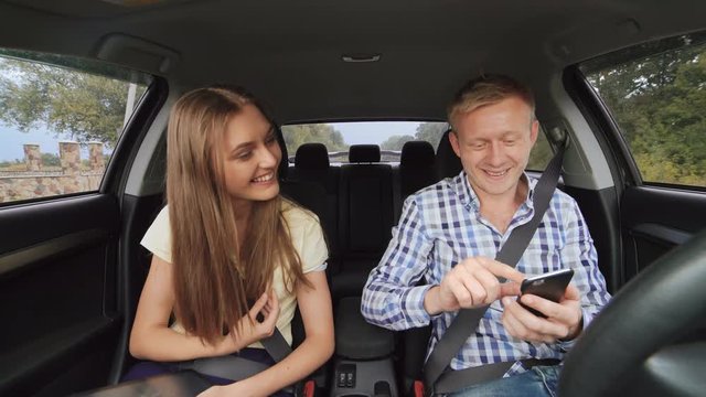 Young adult couple making selfie and kisses in a car. 4K