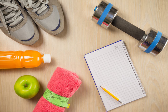 Sport and fitness objects and space notepad on wooden background - Exercise, Health care and diet target plan concept
